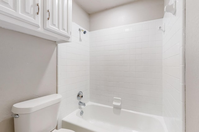 bathroom featuring toilet and tiled shower / bath