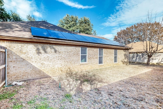 view of side of home with solar panels