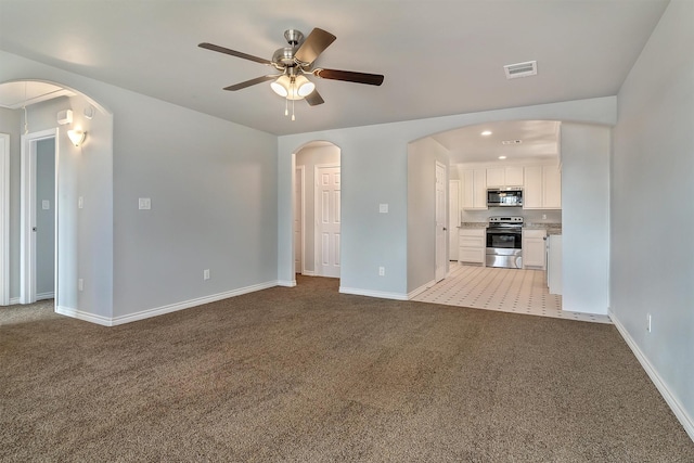 unfurnished living room featuring ceiling fan and light colored carpet