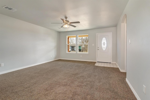 foyer with ceiling fan and dark carpet