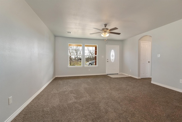 unfurnished living room featuring ceiling fan and dark colored carpet