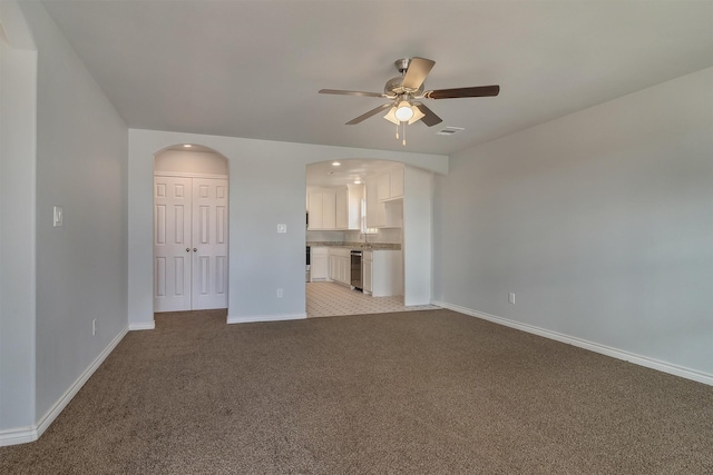 unfurnished living room with light carpet and ceiling fan