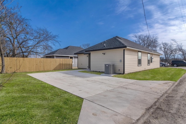 back of property featuring a lawn and central AC