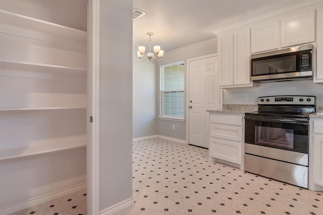 kitchen with stainless steel appliances, white cabinetry, light stone counters, and a notable chandelier