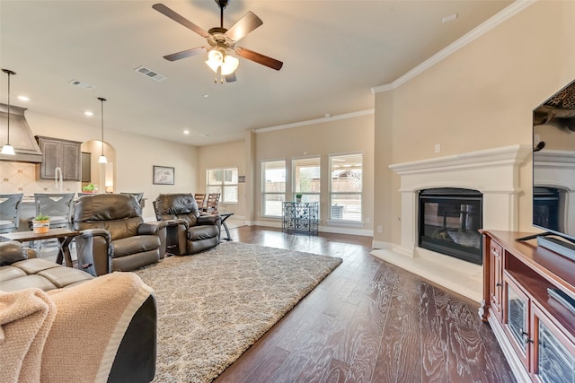 living room featuring ornamental molding, dark hardwood / wood-style floors, and ceiling fan