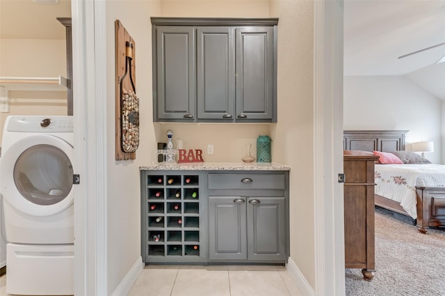 laundry room featuring washer / clothes dryer, light tile patterned floors, and cabinets