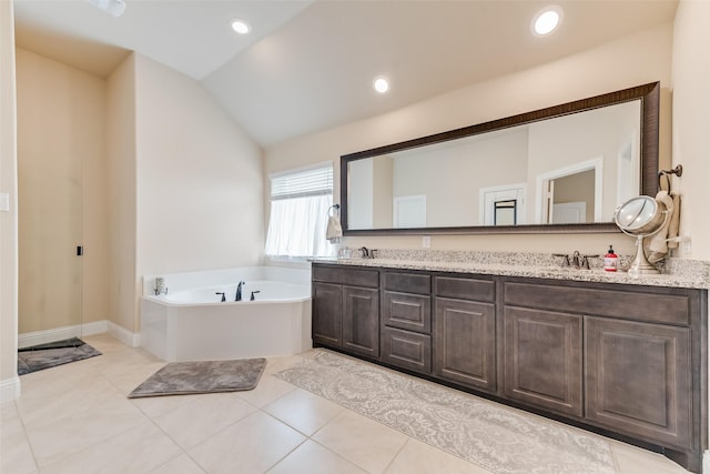 bathroom with tile patterned flooring, a tub, lofted ceiling, and vanity