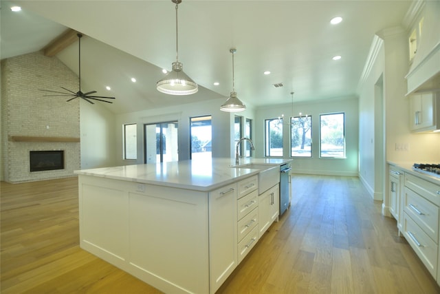 kitchen with white cabinetry, a spacious island, light wood-type flooring, custom range hood, and pendant lighting