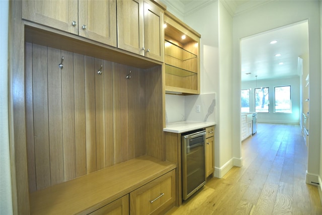 mudroom with ornamental molding, light hardwood / wood-style floors, and wine cooler