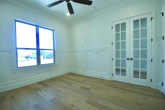 empty room with ceiling fan, ornamental molding, french doors, and light wood-type flooring