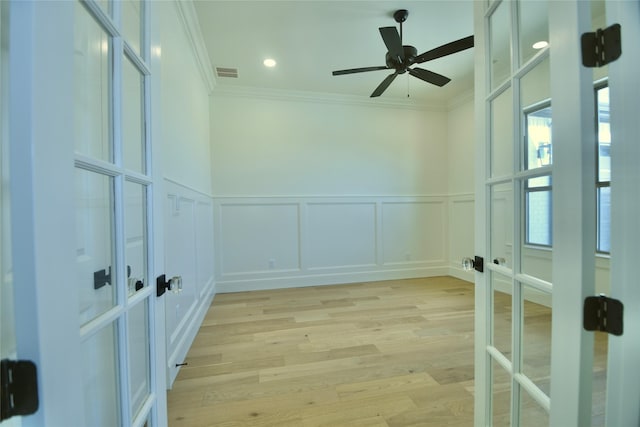 spare room with ceiling fan, light hardwood / wood-style flooring, ornamental molding, and french doors