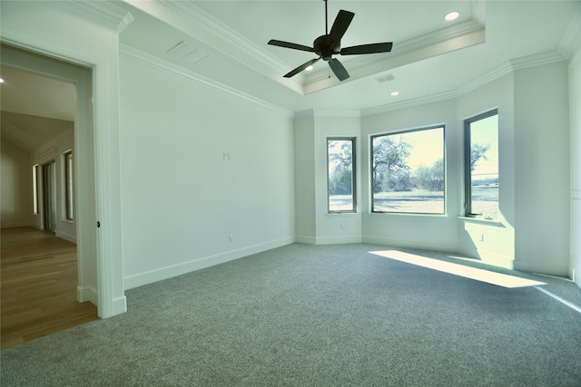 unfurnished room with ceiling fan, a tray ceiling, crown molding, and carpet flooring