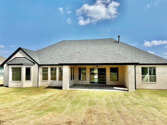 rear view of property featuring ceiling fan, a yard, and a patio