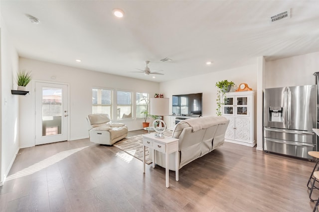 living area with wood finished floors, visible vents, and ceiling fan