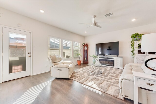 living room with light hardwood / wood-style flooring, ceiling fan, and vaulted ceiling