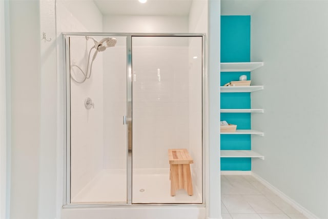 bathroom featuring tile patterned floors, baseboards, and a shower stall