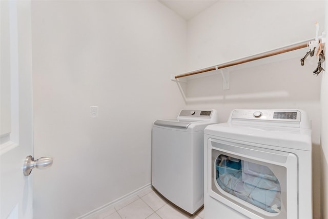 laundry area with light tile patterned floors, laundry area, baseboards, and separate washer and dryer