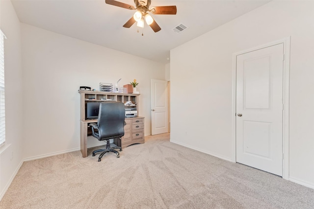 home office featuring a ceiling fan, light colored carpet, visible vents, and baseboards