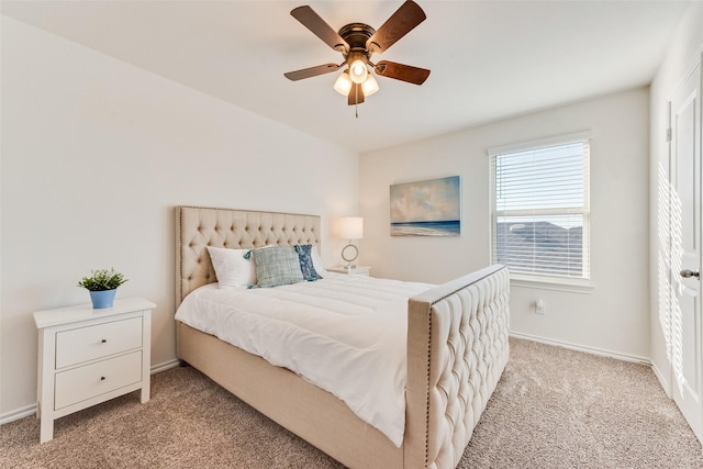 bedroom featuring light colored carpet, baseboards, and ceiling fan