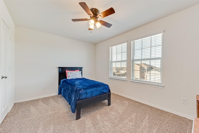 bedroom featuring light carpet, ceiling fan, and baseboards