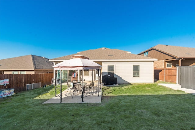 rear view of house featuring a gazebo, a fenced backyard, a patio area, and a yard