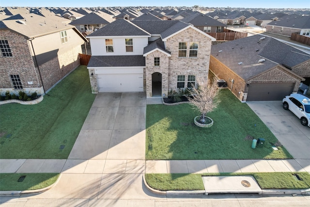 view of front of property featuring a residential view, an attached garage, concrete driveway, and a front lawn