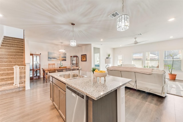 kitchen featuring visible vents, open floor plan, dishwasher, light wood-style floors, and a sink