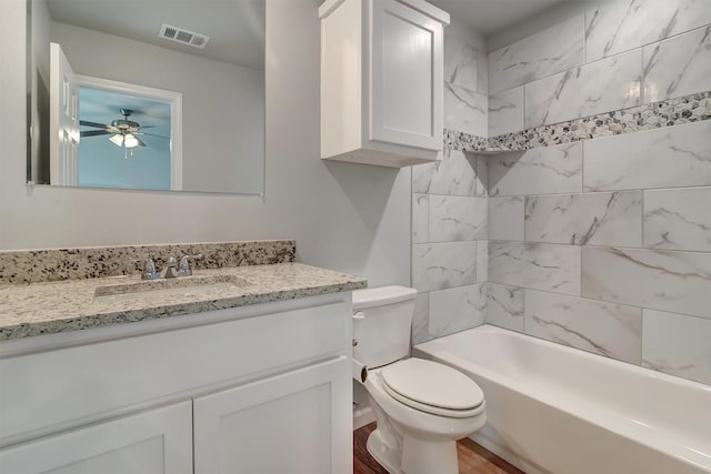 full bathroom featuring wood-type flooring, toilet, vanity, and tiled shower / bath combo