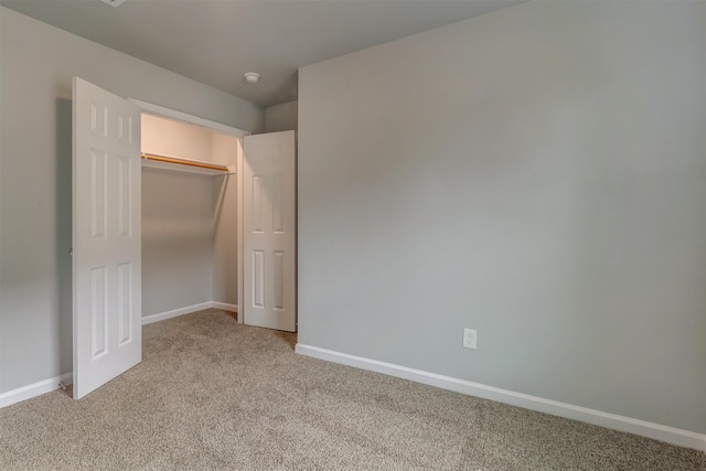 unfurnished bedroom with a closet and light carpet