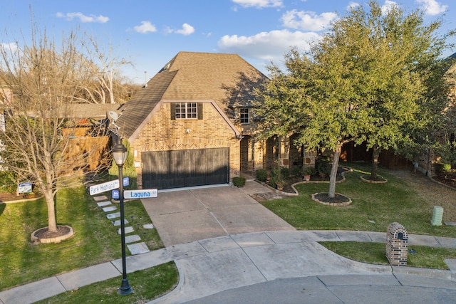 tudor house featuring a front yard and a garage