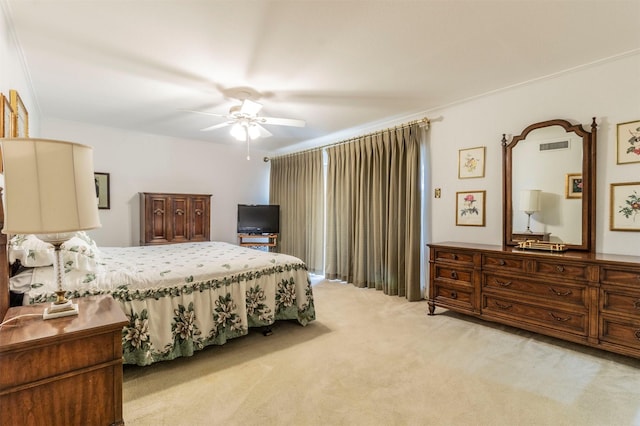 carpeted bedroom with ceiling fan and ornamental molding