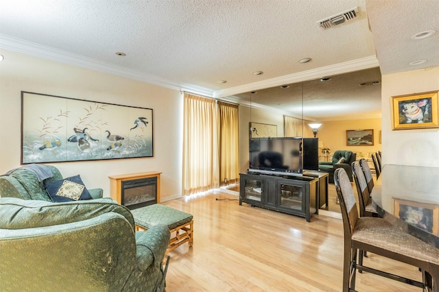 living room featuring crown molding, a textured ceiling, and wood-type flooring