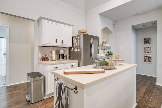 kitchen with dark hardwood / wood-style flooring, a center island, white cabinets, and stainless steel refrigerator