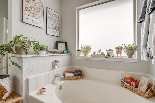 bathroom featuring tiled bath and a healthy amount of sunlight