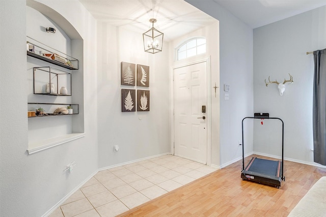 entrance foyer with light hardwood / wood-style floors and a notable chandelier