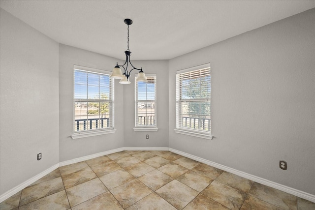 unfurnished room featuring plenty of natural light and a chandelier