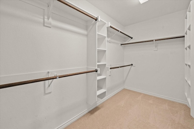 walk in closet featuring light carpet