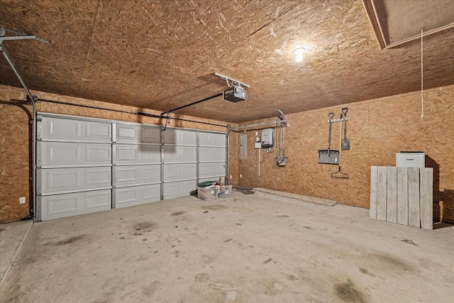 garage with electric panel and a garage door opener