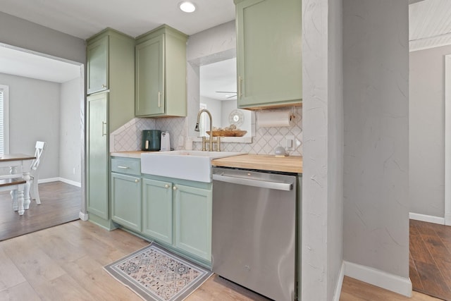 kitchen with backsplash, stainless steel dishwasher, light hardwood / wood-style flooring, and green cabinetry