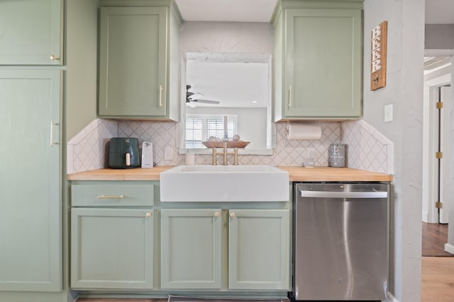 kitchen with decorative backsplash, sink, stainless steel dishwasher, and green cabinetry