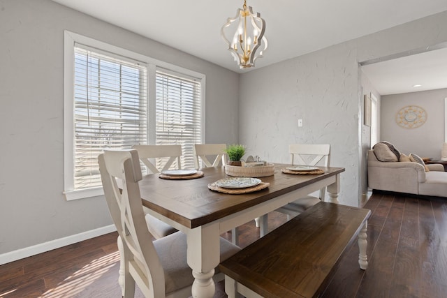 dining area with dark hardwood / wood-style flooring and a notable chandelier