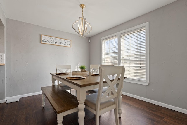 dining area with dark wood-type flooring and a notable chandelier