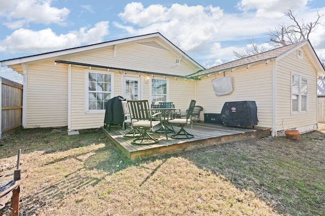 rear view of property featuring a wooden deck and a yard