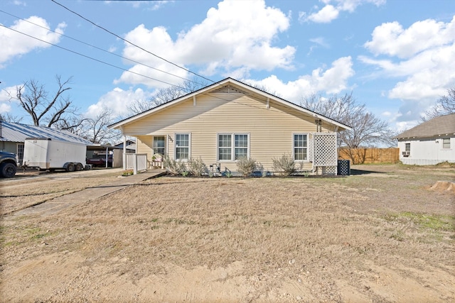 rear view of house with a carport, a yard, and central AC unit