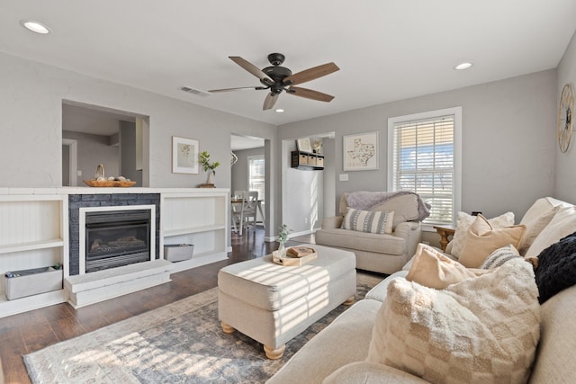 living room featuring ceiling fan and dark hardwood / wood-style floors