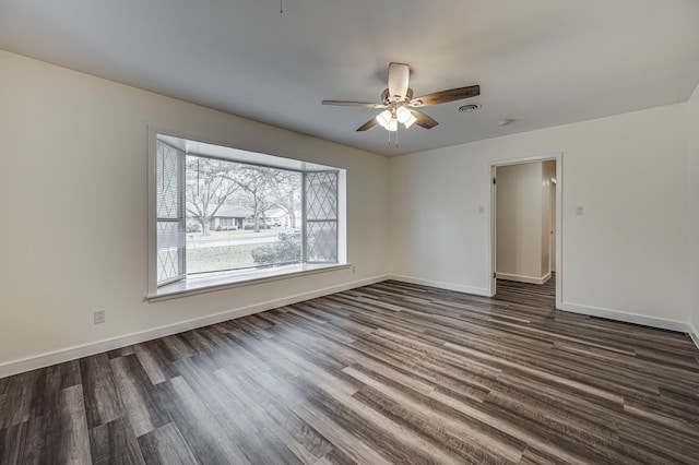 spare room with ceiling fan and dark wood-type flooring