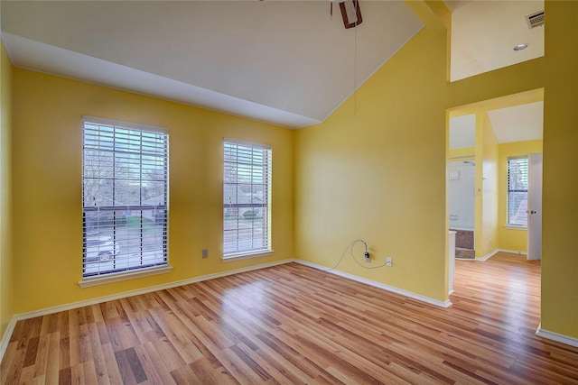 unfurnished room with high vaulted ceiling and light hardwood / wood-style flooring