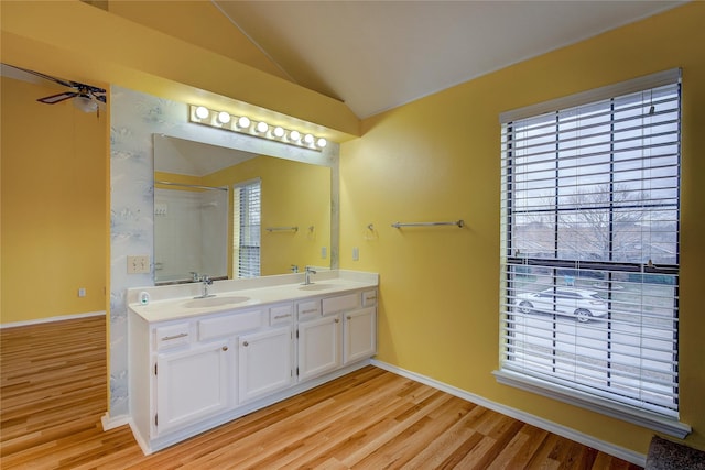 bathroom with vaulted ceiling, ceiling fan, hardwood / wood-style floors, and vanity