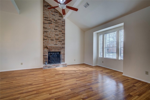 unfurnished living room featuring a brick fireplace, hardwood / wood-style flooring, high vaulted ceiling, and ceiling fan