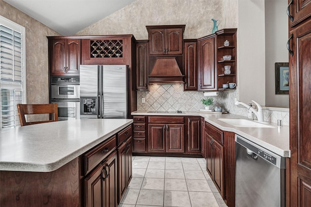 kitchen with premium range hood, lofted ceiling, sink, light tile patterned floors, and stainless steel appliances